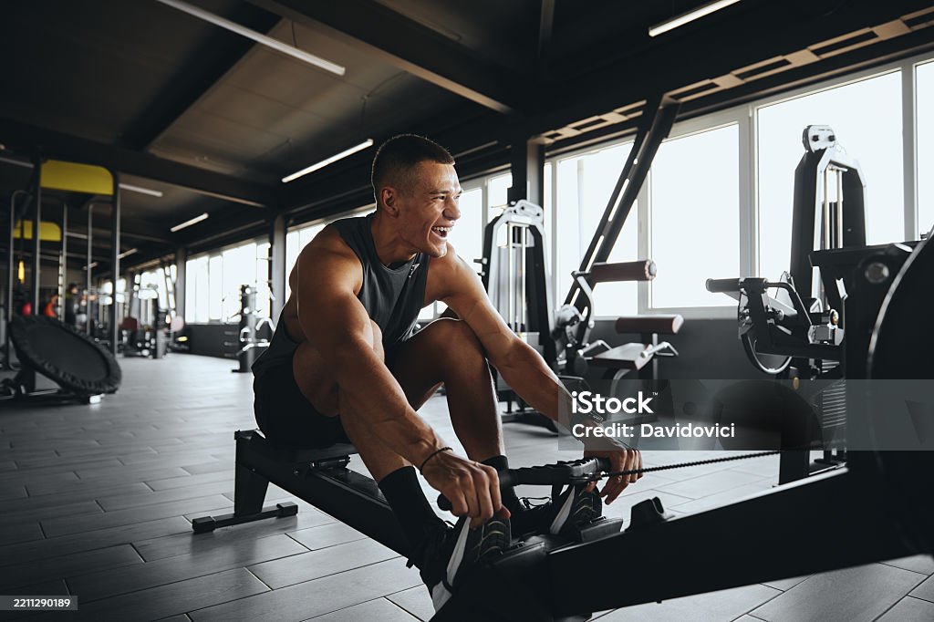 A man is using a sporting machine in the gym.